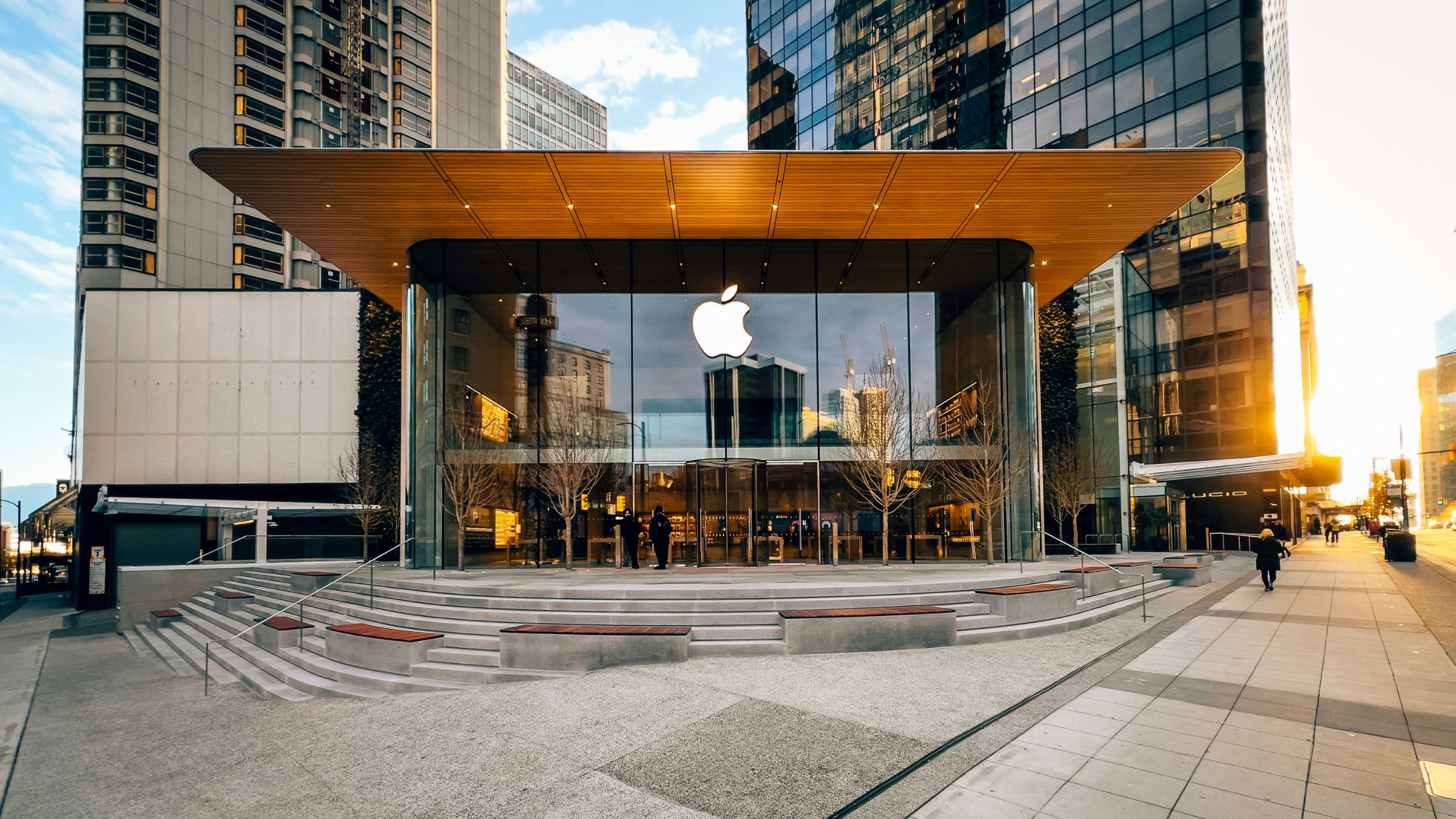 Apple retail store with glass facade and large logo at a downtown street corner.