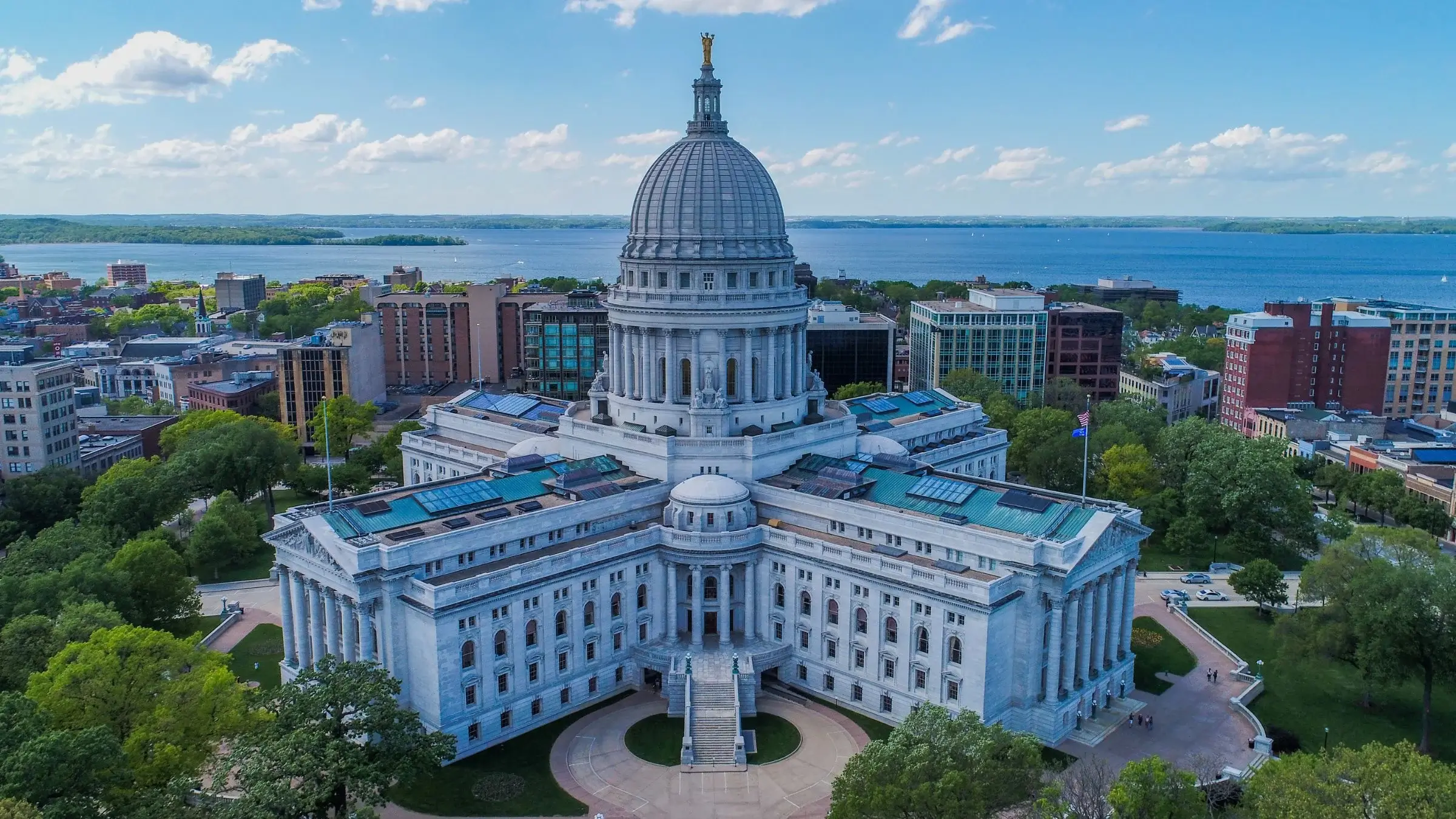 Aerial view of the Wisconsin State Capitol building in Madison with blue sky and surrounding cityscape