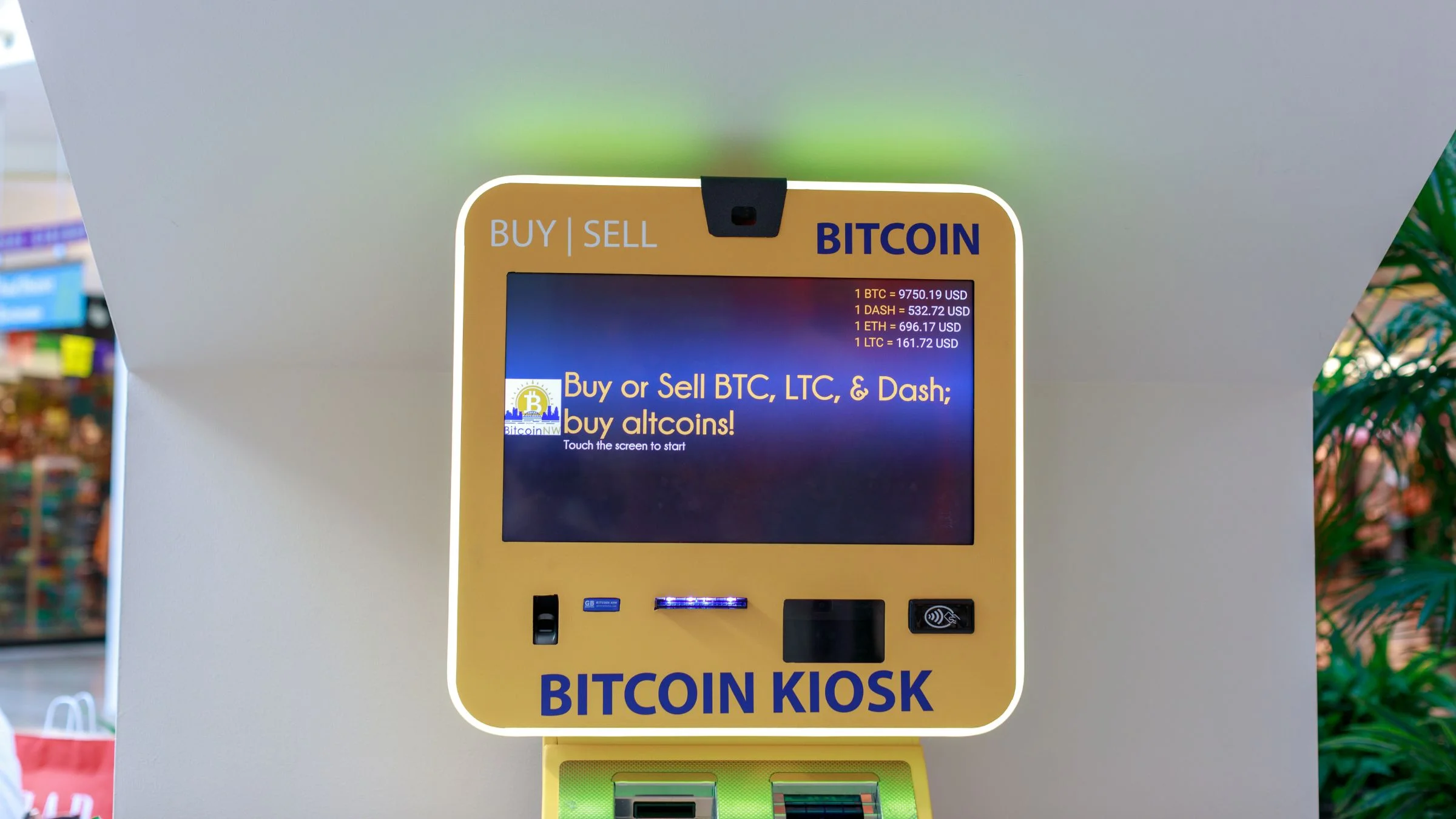 Bitcoin kiosk in a public indoor space displaying buy and sell options for bitcoin and altcoins.