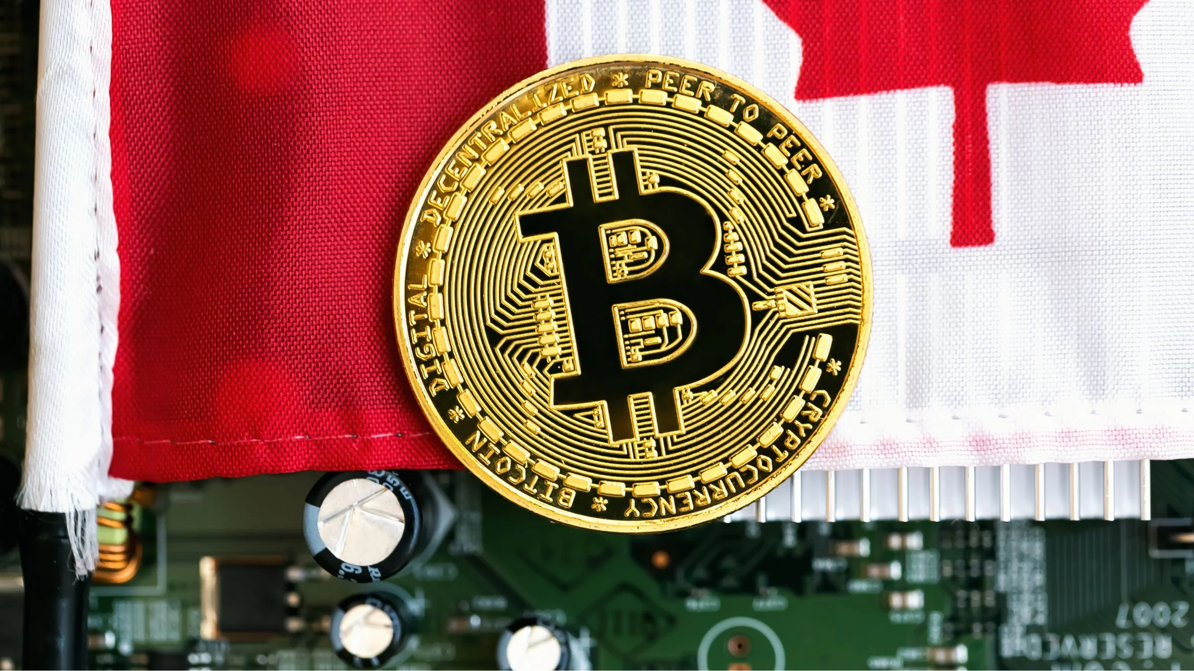 Gold Bitcoin token placed in front of a Canadian flag above visible computer circuit components.