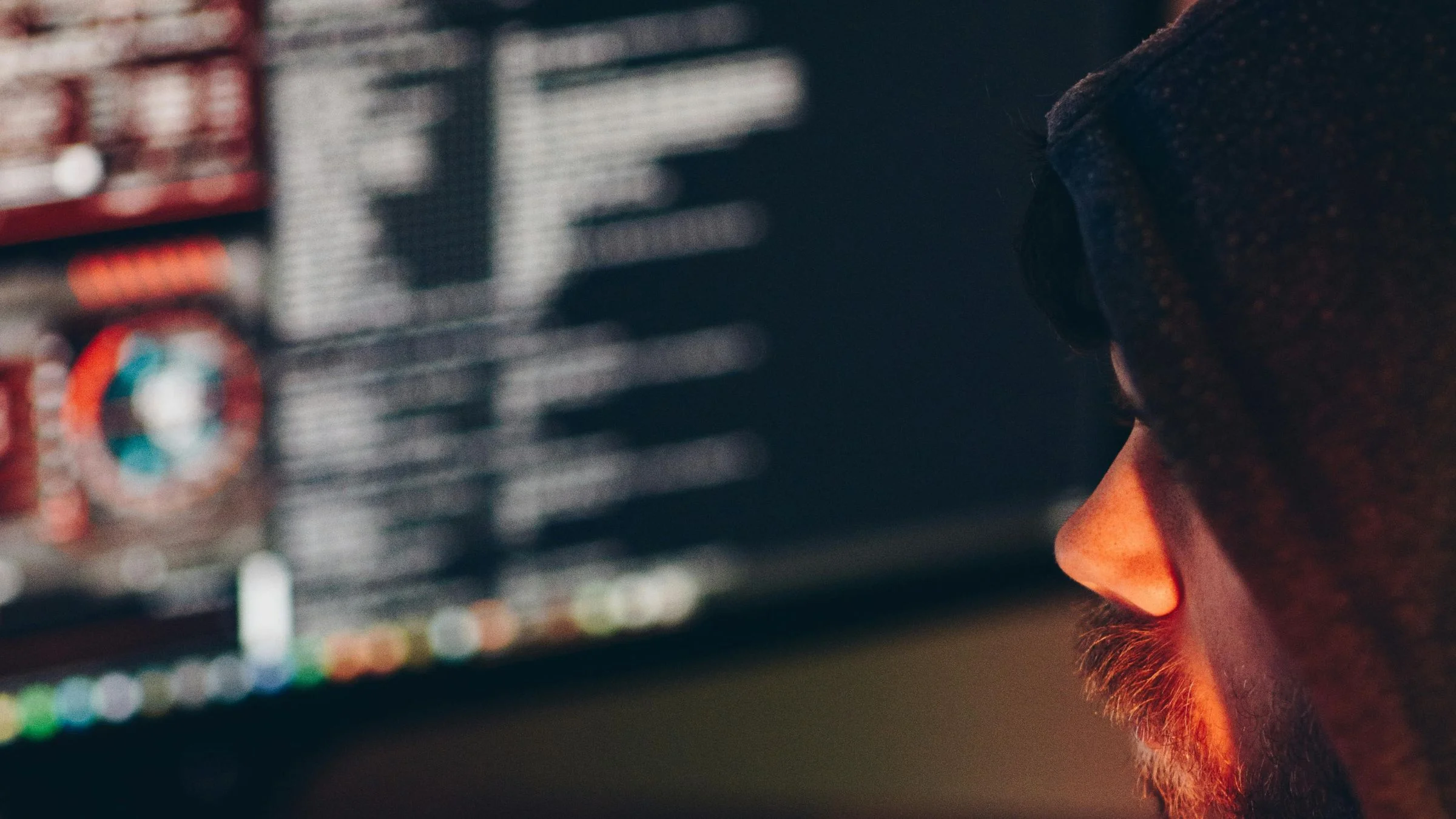 Hacker looking at computer screen with code on it