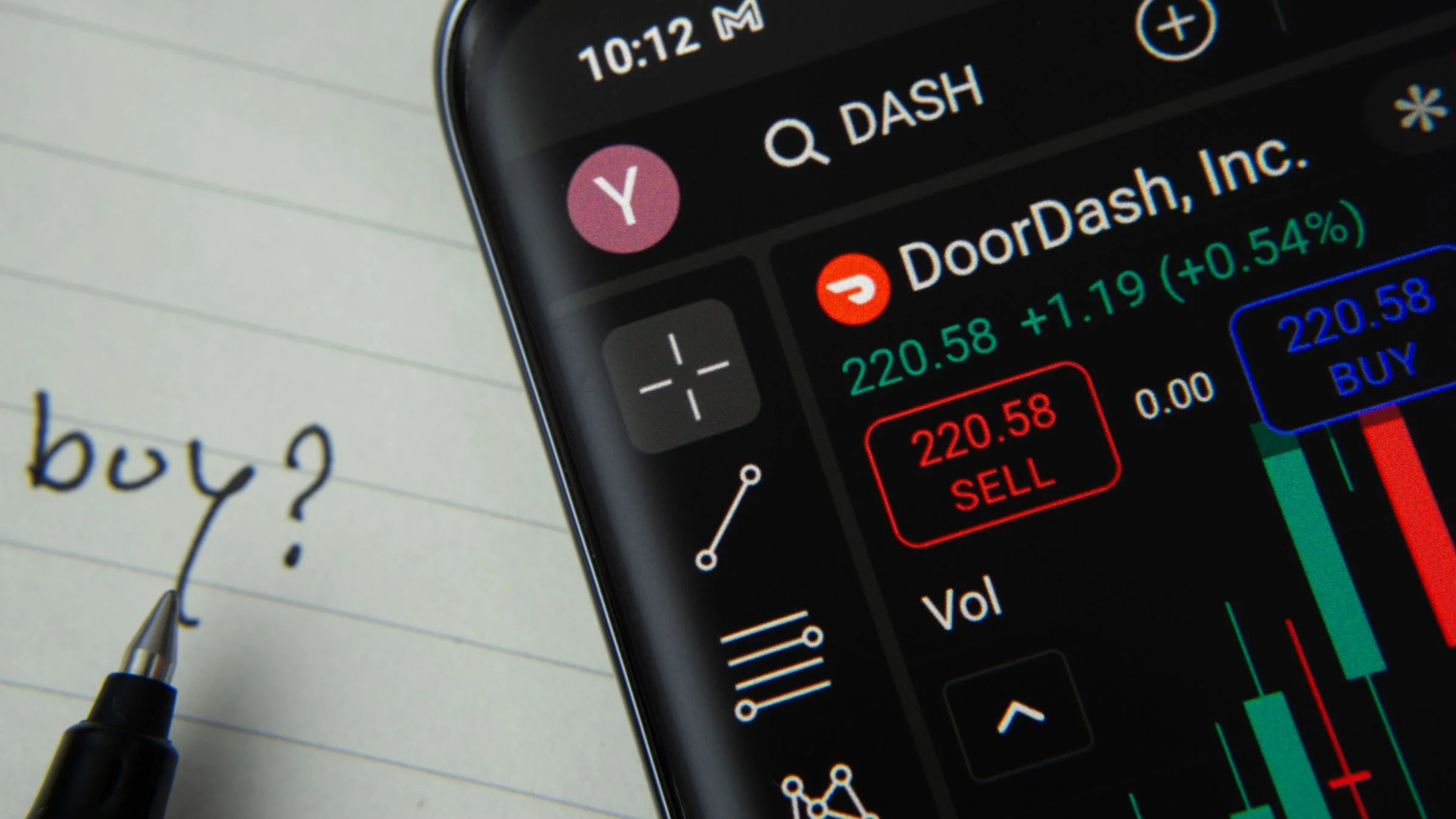 Smartphone trading screen showing DoorDash stock price, buy and sell buttons, and a handwritten buy note.