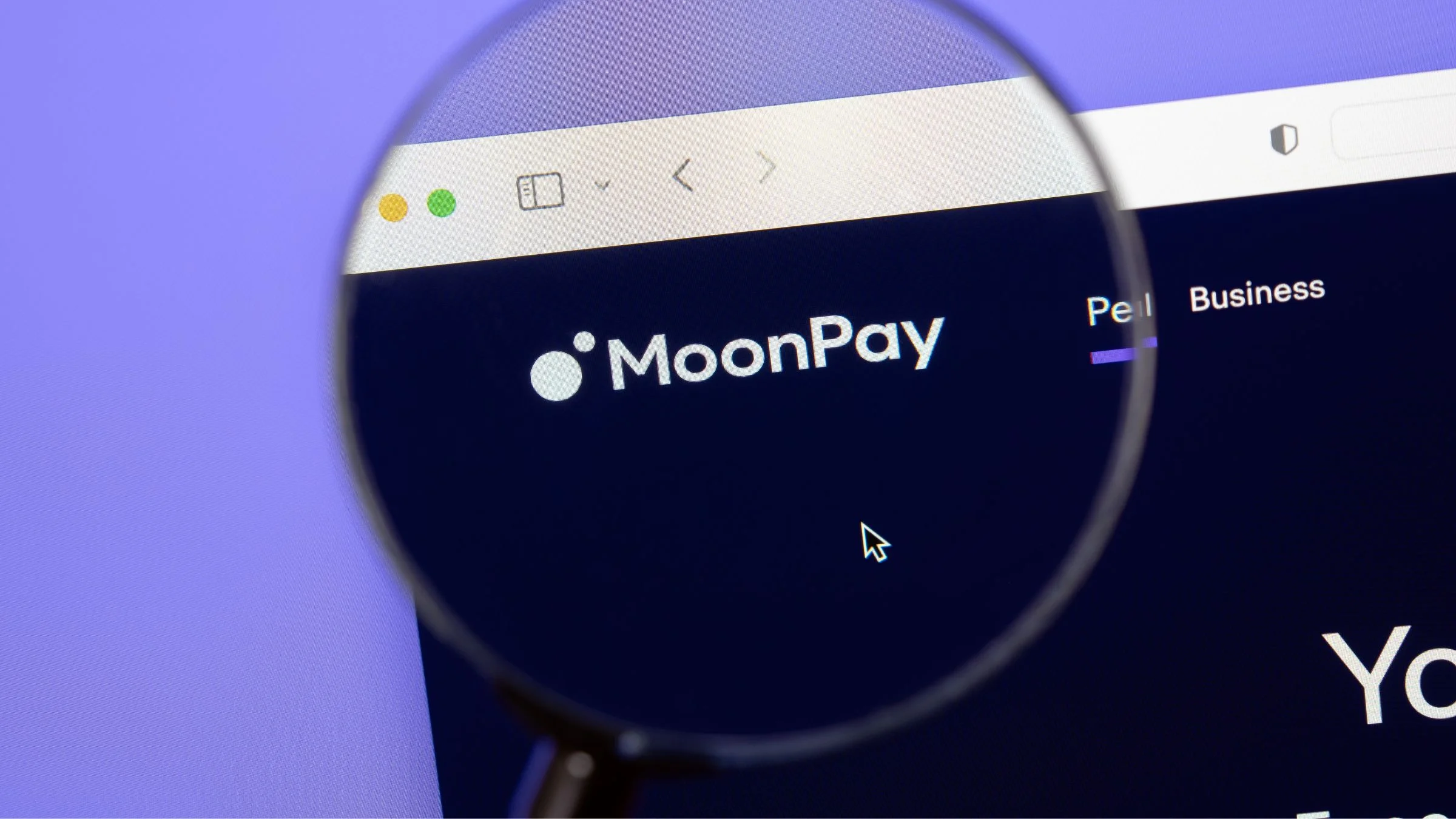 Magnifying glass over the MoonPay logo on a website displayed on a computer screen.
