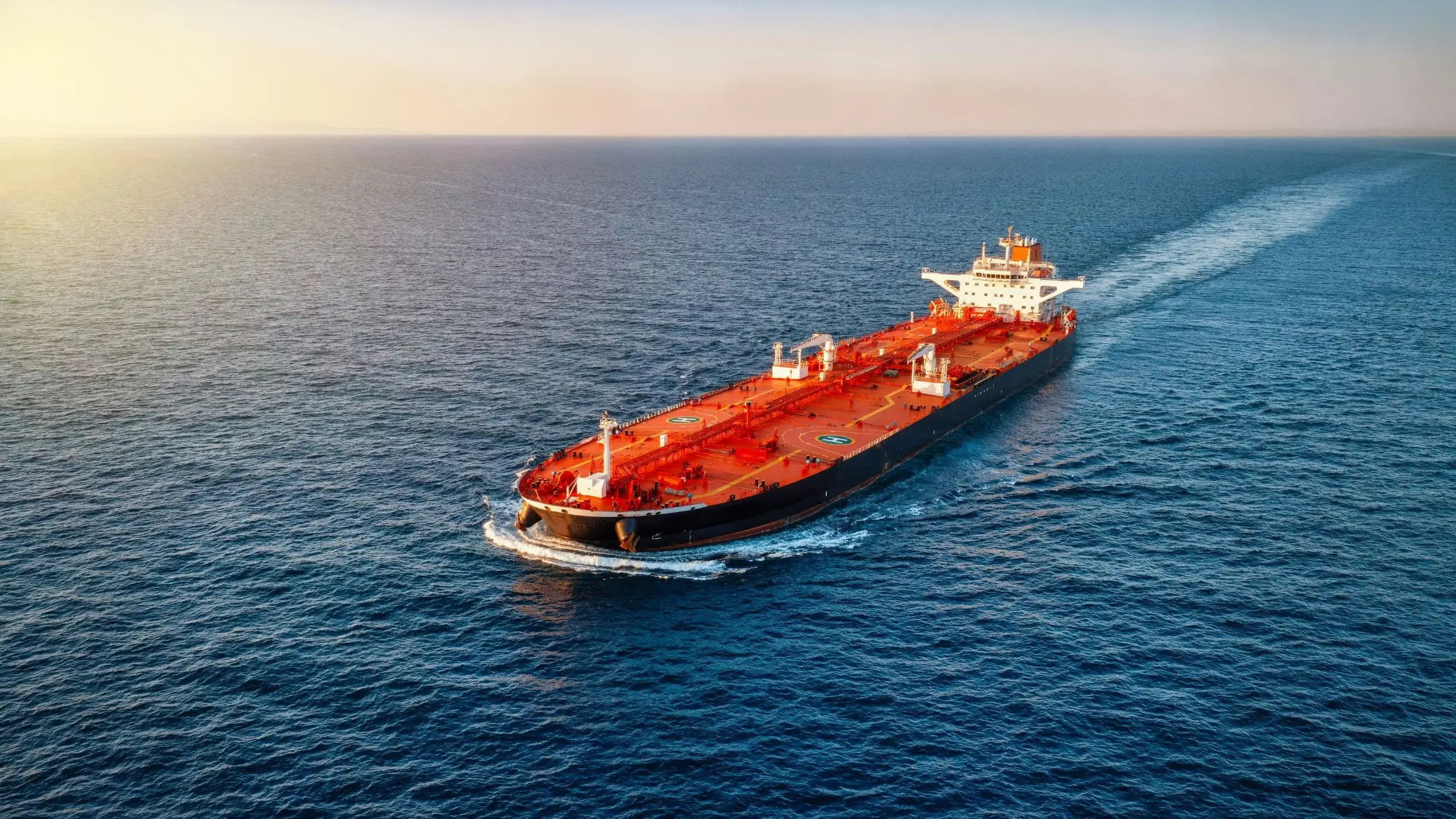 Oil tanker crossing open water at sea, representing rising energy market tension and renewed geopolitical risk near the Strait of Hormuz.