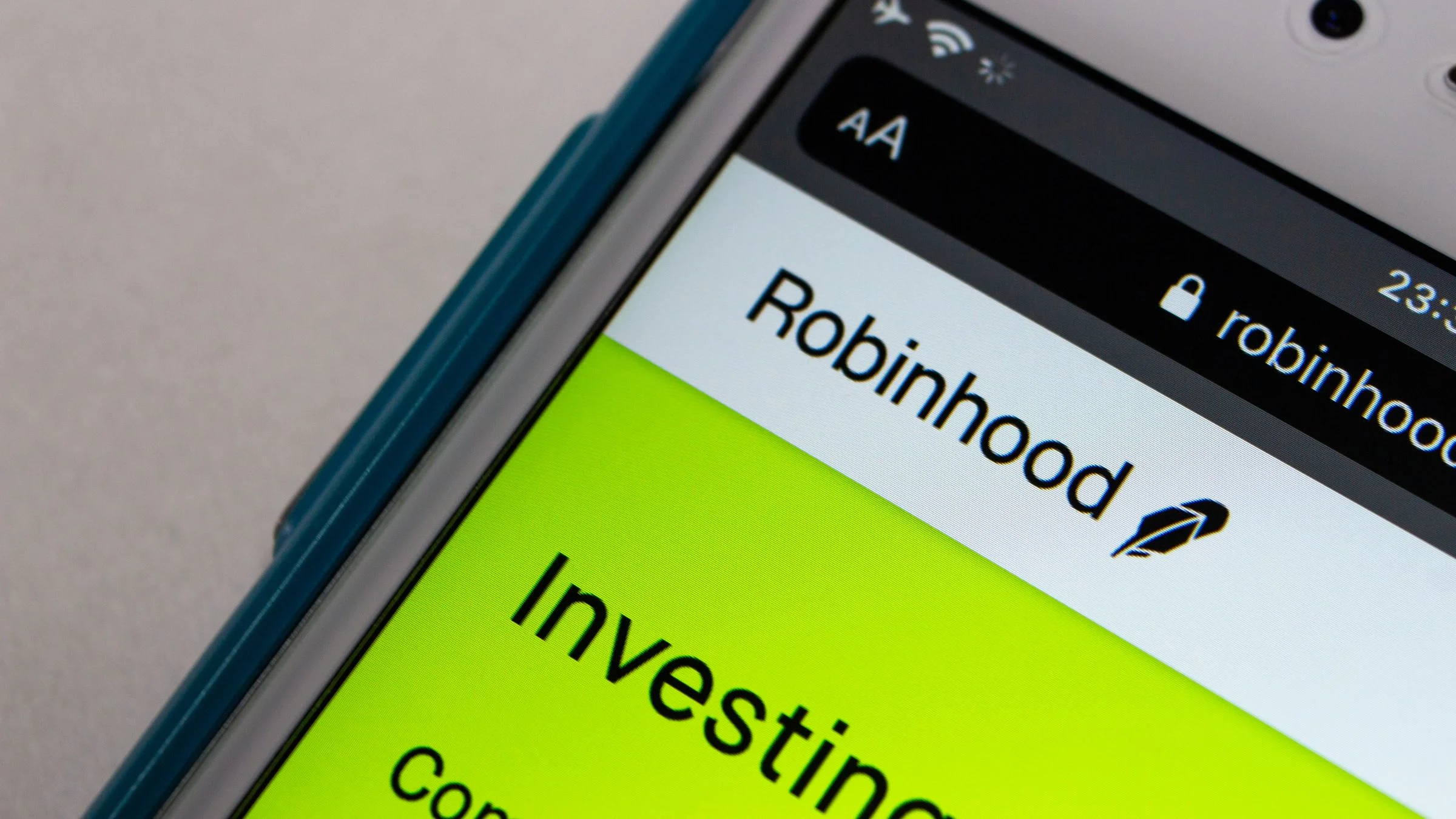 Close-up of a smartphone screen displaying the Robinhood website and investing interface.