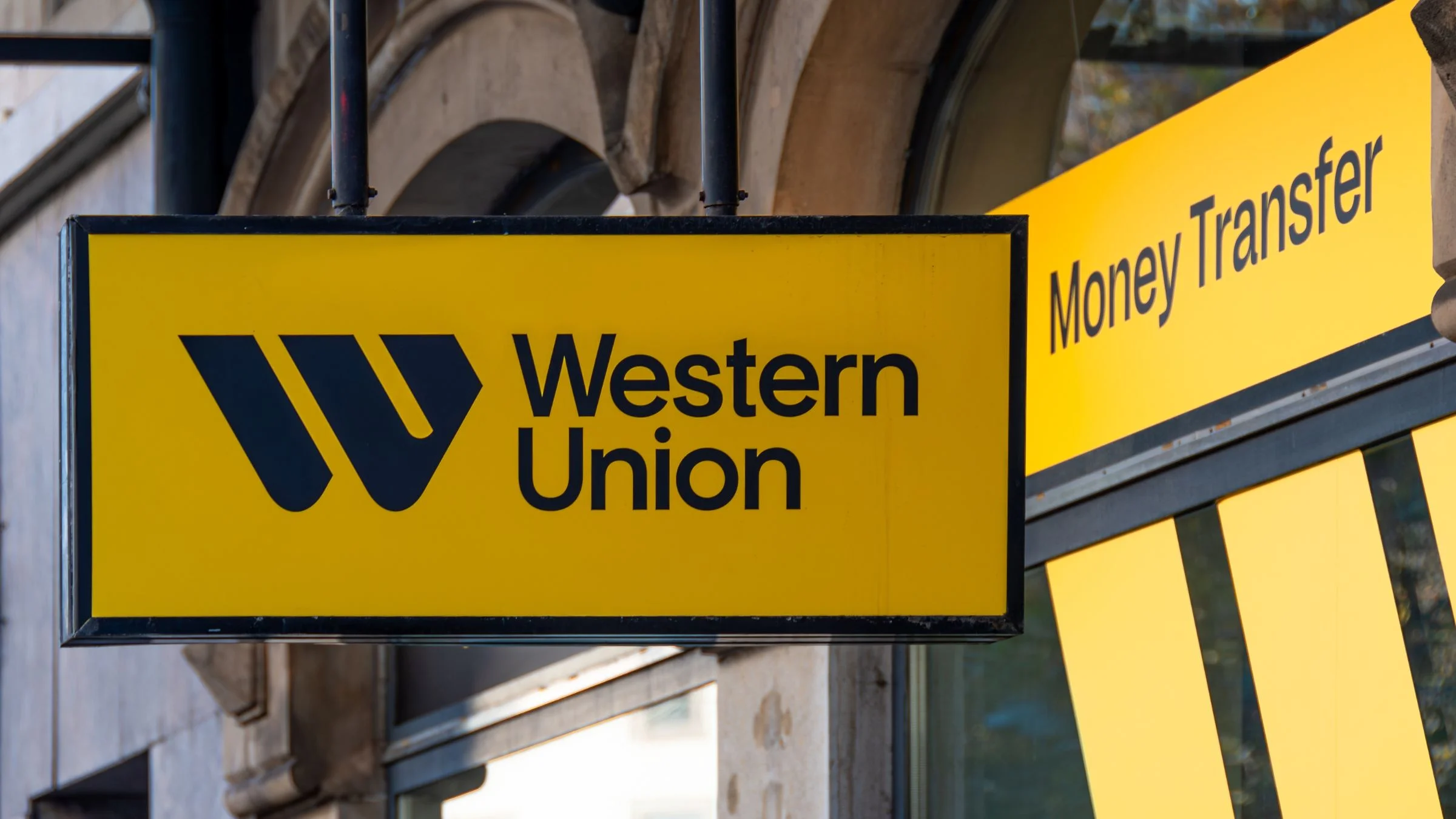 Western Union storefront signs in yellow and black displaying the company name and money transfer service.