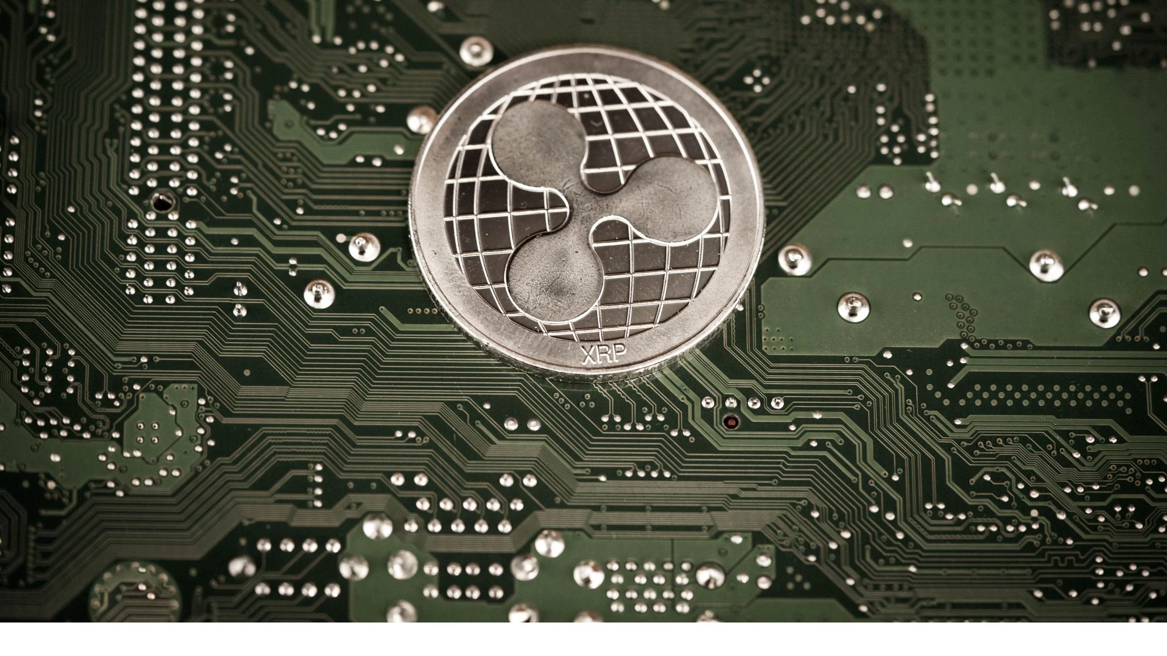 XRP token placed on a green circuit board with visible electronic pathways and components.