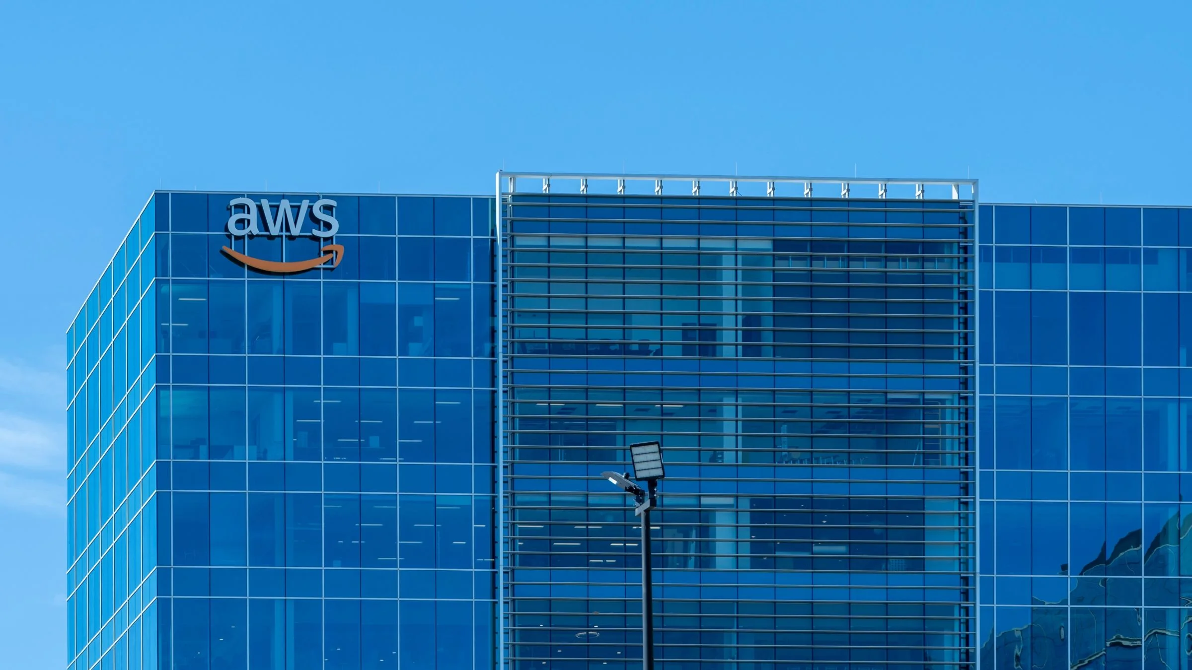 Amazon Web Services (AWS) logo displayed on a modern glass office building