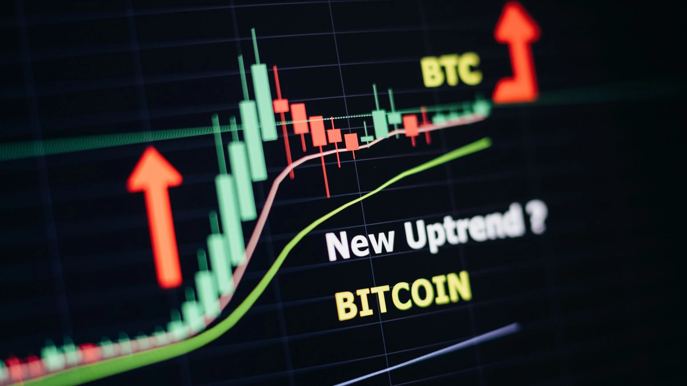 Bitcoin trading chart with rising arrows, candlestick bars, and the text “New Uptrend?” on screen.