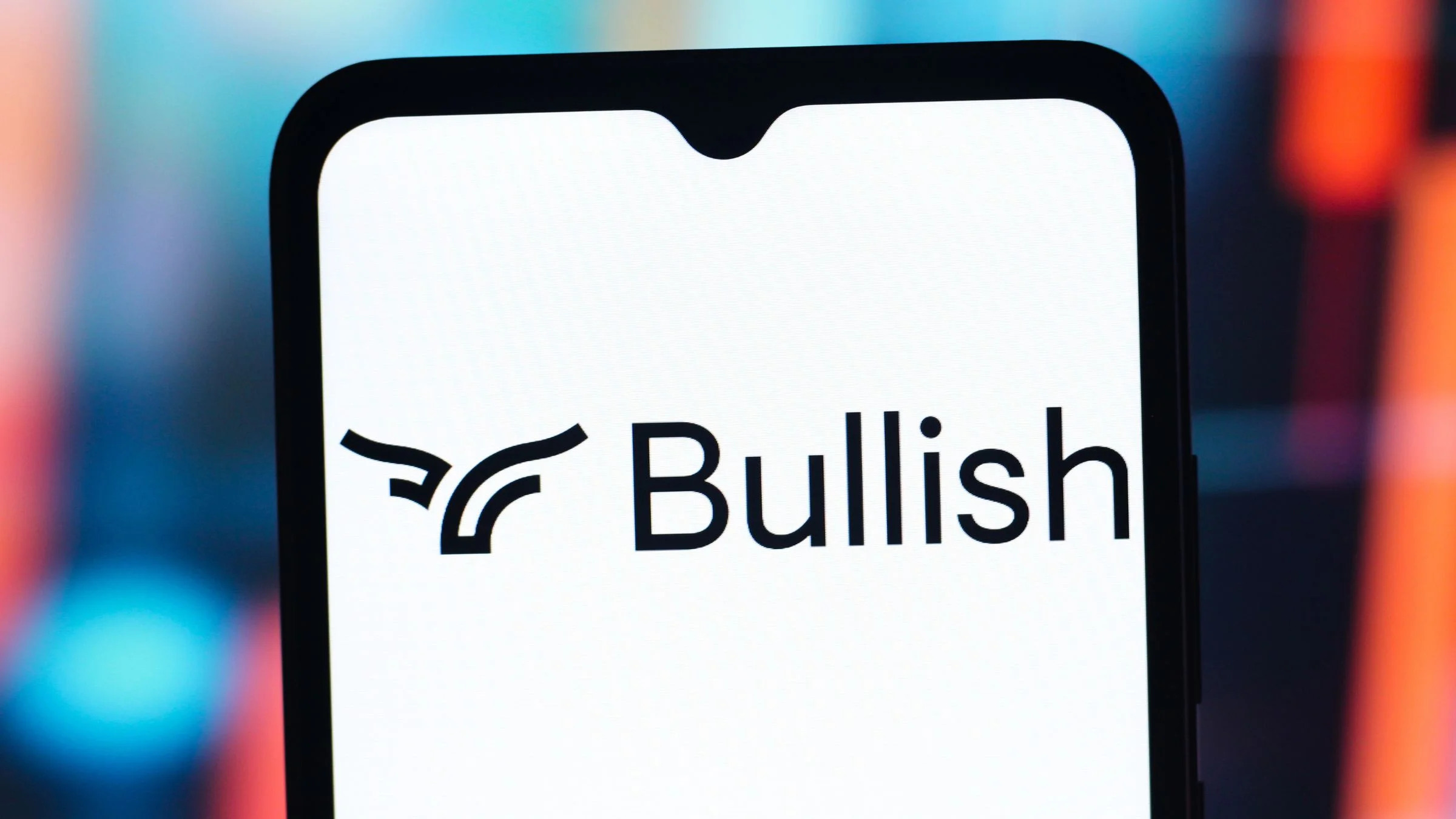 Bullish cryptocurrency exchange logo displayed on a smartphone screen against a colorful blurred background