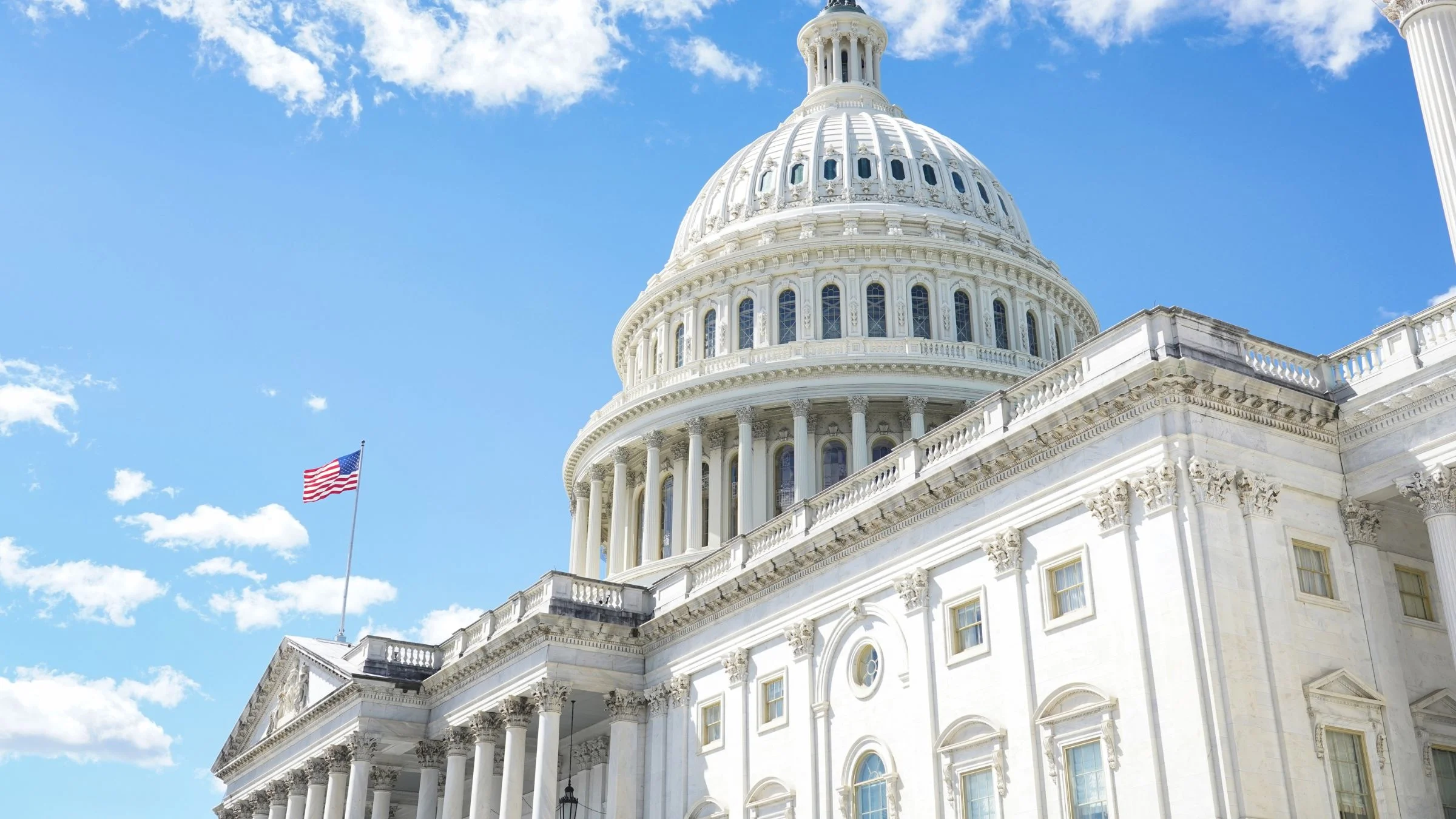 United States Capitol Building against a blue sky with clouds