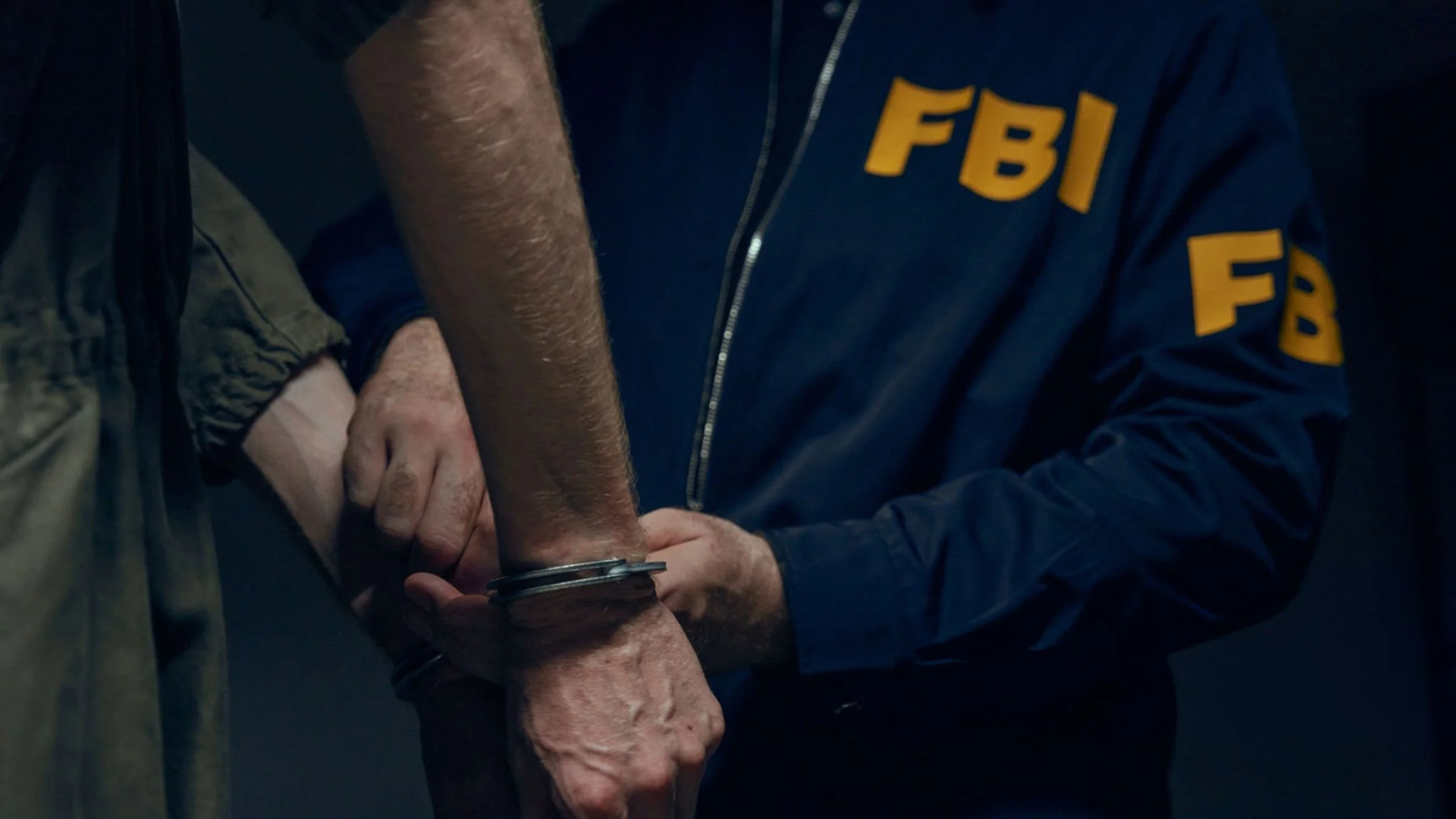 FBI agent placing handcuffs on a suspect's wrists