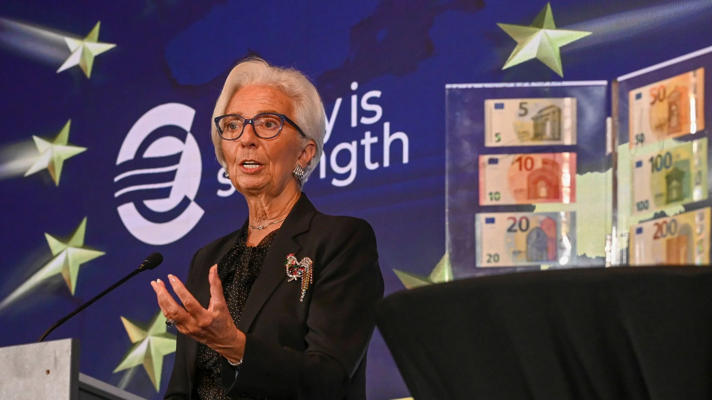 European Central Bank (ECB) President Christine Lagarde speaking beside euro banknotes on display