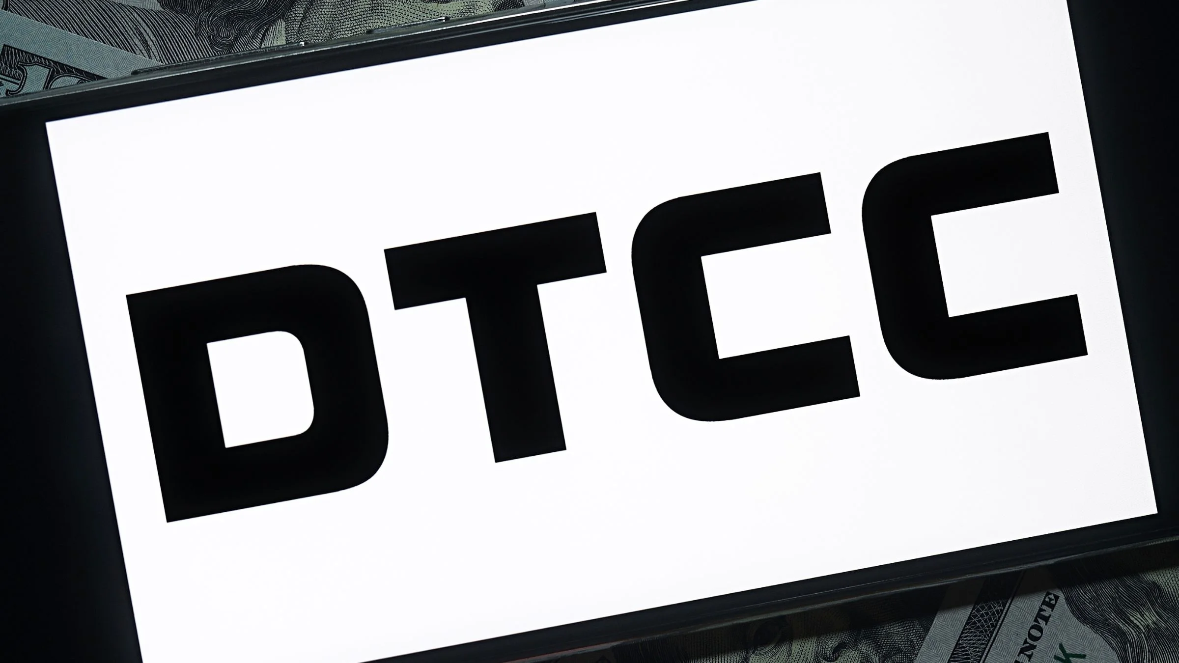 DTCC logo displayed on a screen with U.S. dollar banknotes visible in the background.