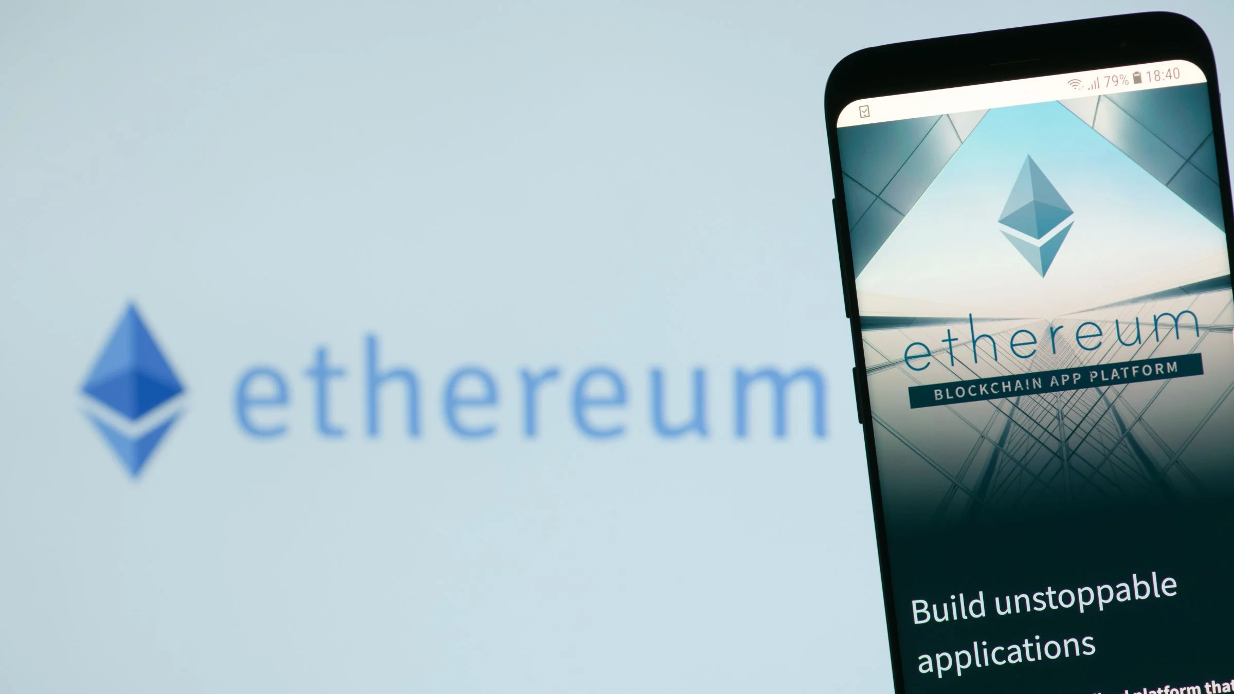 Smartphone displaying the Ethereum website with the Ethereum logo and branding visible in the blurred background