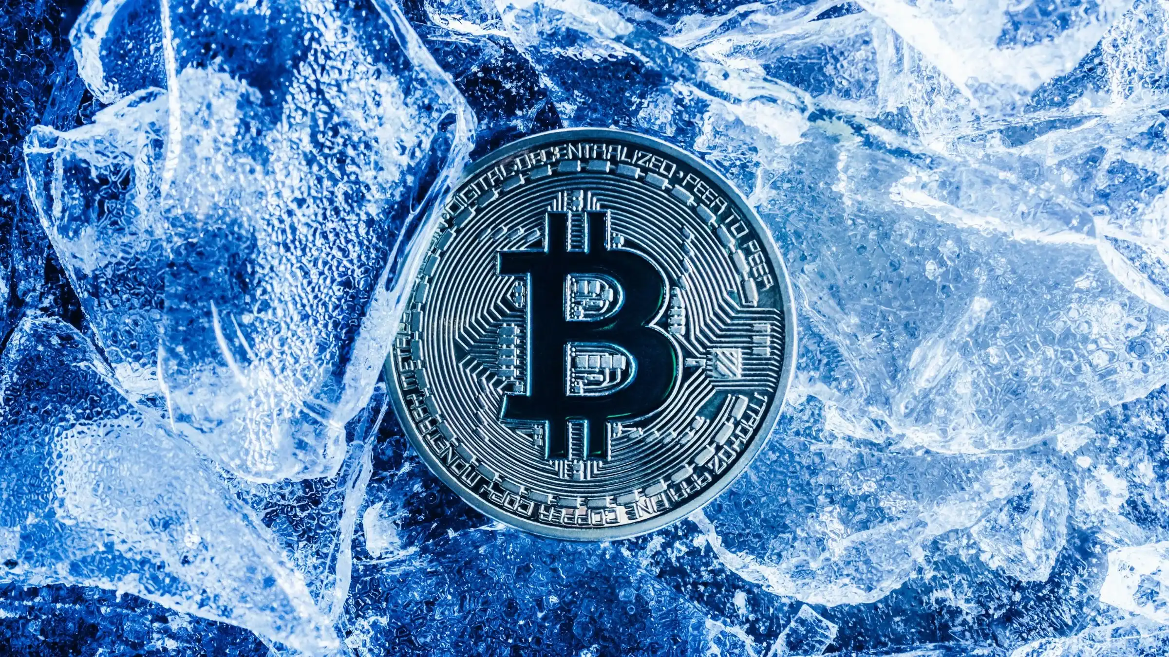 Bitcoin cryptocurrency coin surrounded by ice and frozen blue textures