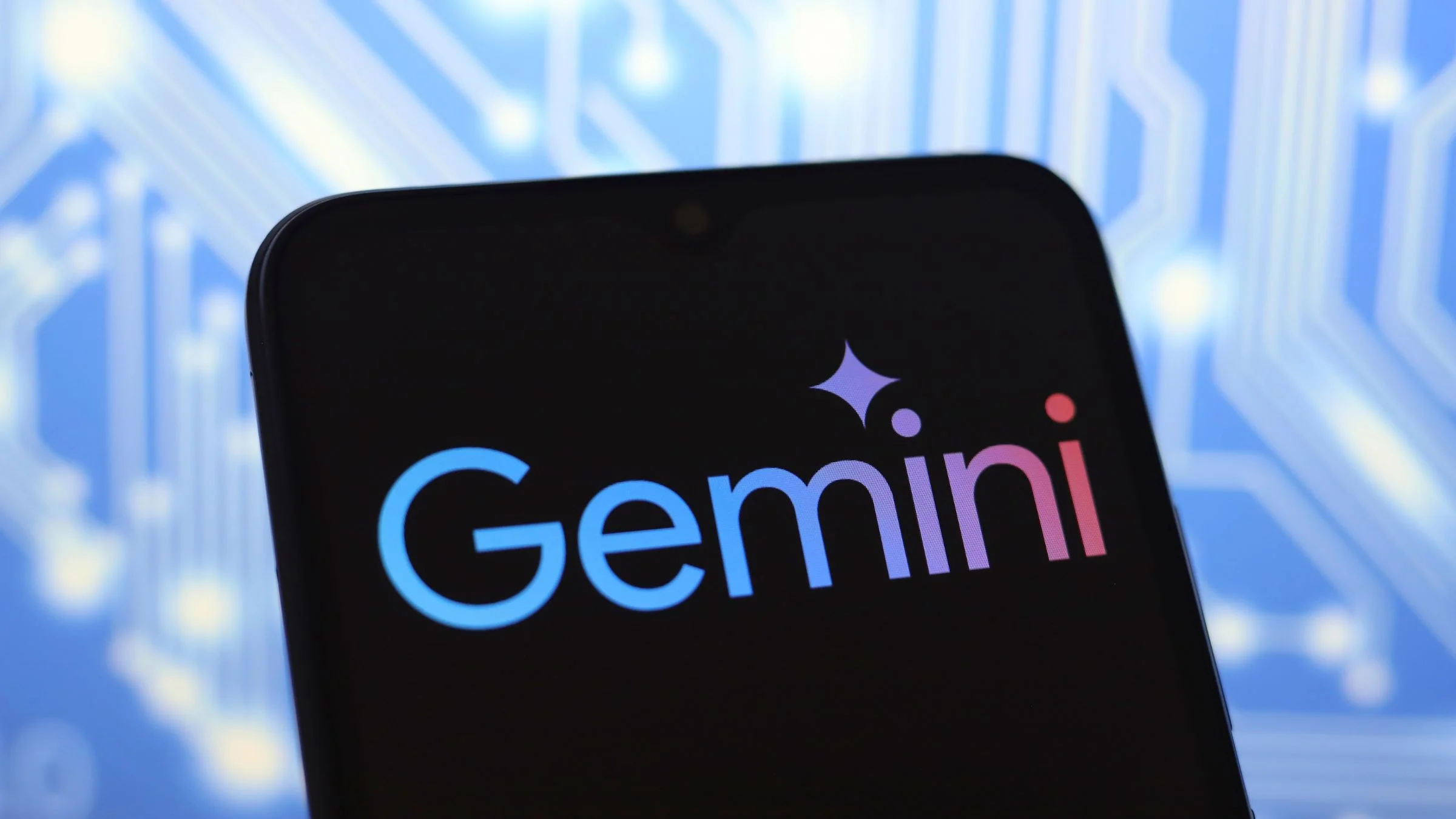 Google Gemini AI logo displayed on a smartphone screen against a blue circuit board background