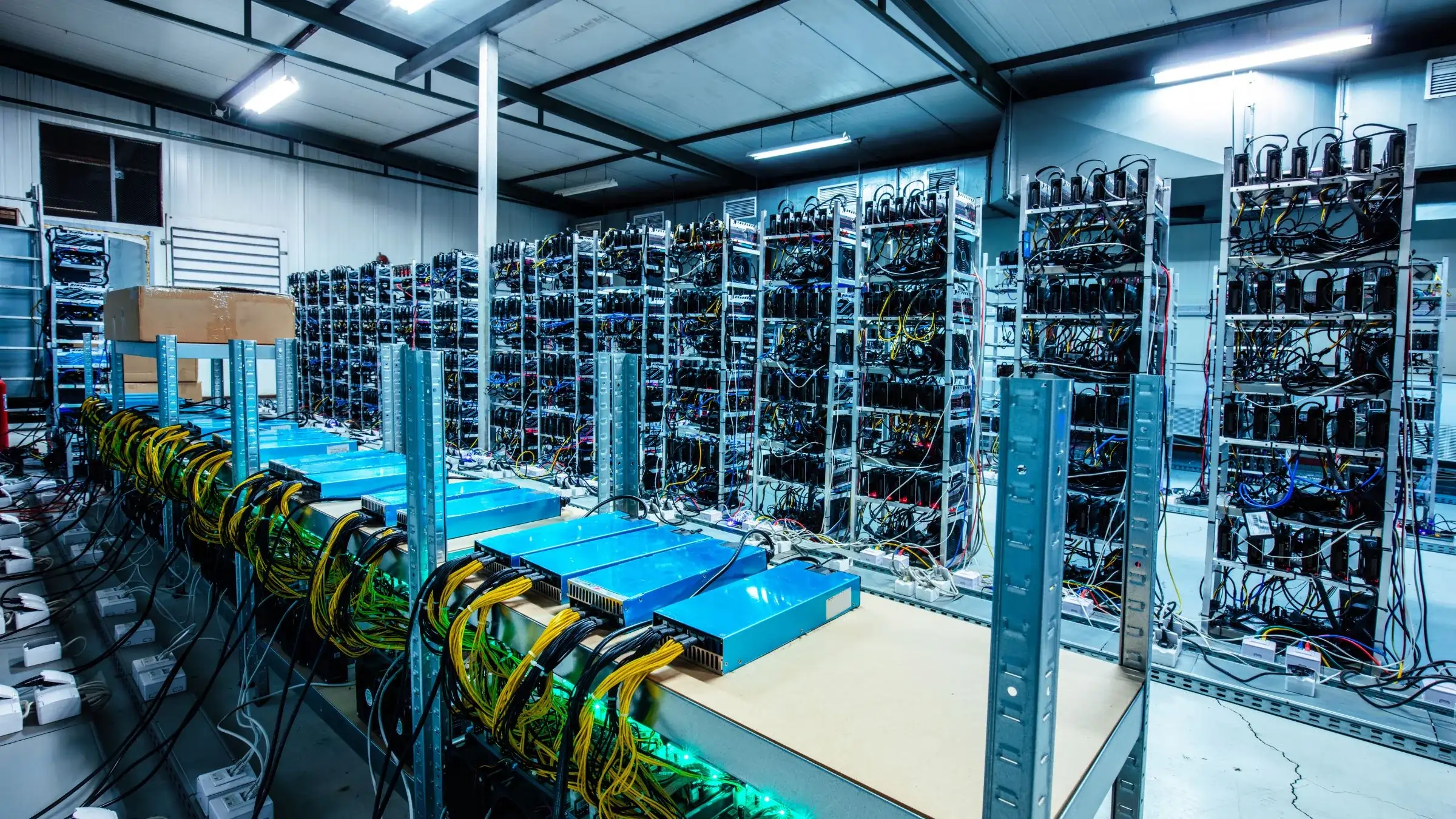Interior view of a large cryptocurrency mining farm with rows of mining rigs and servers