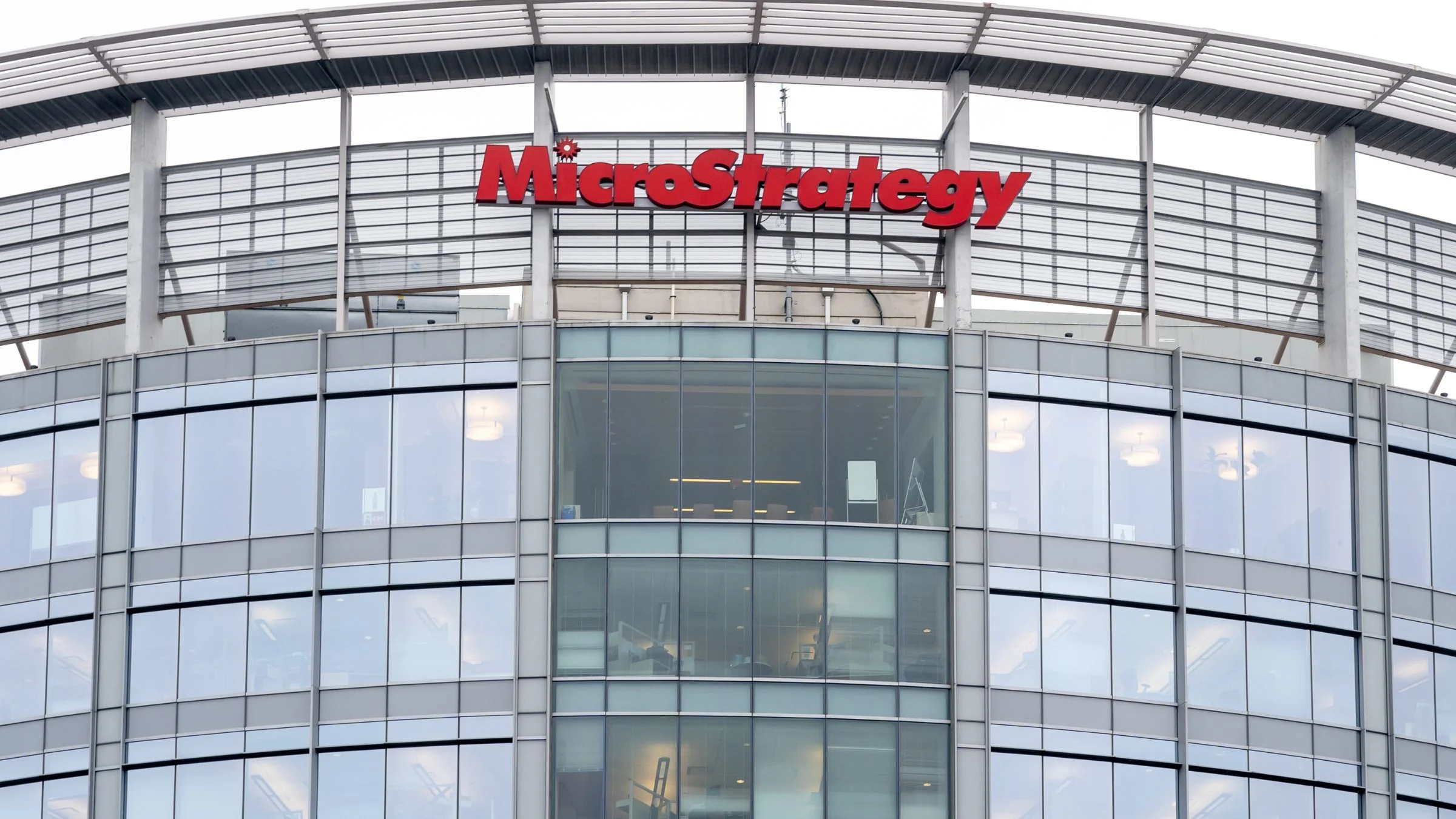 MicroStrategy sign mounted on the upper exterior of a modern office building with glass windows.
