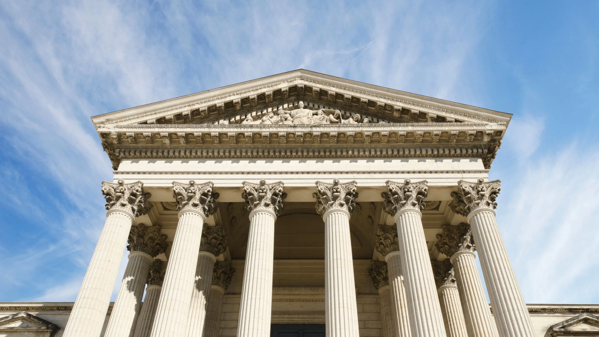 Low-angle view of a neoclassical courthouse building with tall stone columns