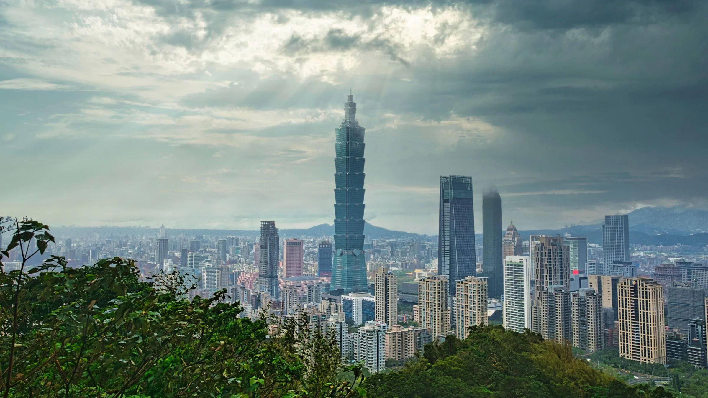 Panoramic view of Taipei city skyline with Taipei 101 skyscraper under cloudy skies