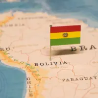 Bolivian flag pin placed on a map of South America near Bolivia and Brazil.