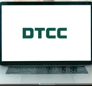 DTCC logo displayed on a laptop screen on a wooden desk with books, plants, and a watch nearby