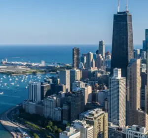 Aerial view of Chicago skyscrapers beside Lake Michigan under a clear blue sky