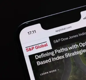 Smartphone showing the S&P Global website with S&P Dow Jones Indices branding on screen against a dark background.