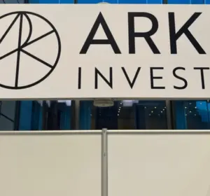ARK Invest logo and company name displayed on a large white sign at an indoor event