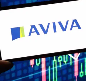 Hand holding a smartphone displaying the Aviva logo against colorful financial market charts in the background.
