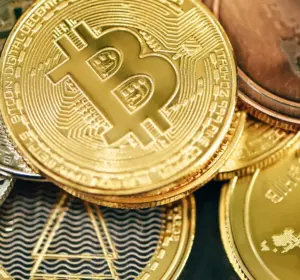 Close-up of gold and silver cryptocurrency coins with a prominent Bitcoin coin at the center.