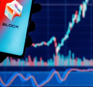 Block company logo displayed on a smartphone in front of a rising financial market chart