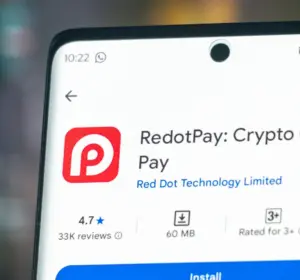 Smartphone displaying the RedotPay crypto card application page with ratings, downloads, and install button visible.